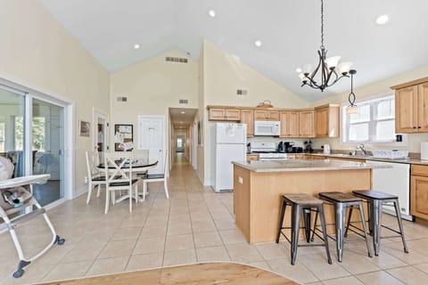 Full Hawk's Haven kitchen with island seating, breakfast or games/crafting table, and central hallway to the left