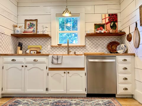 Kitchen with stainless steel dishwasher and farm sink. 
