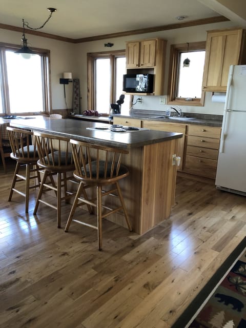 Fully-stocked kitchen with refrigerator, range/stove, microwave and sink.