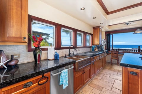Wall-to-wall windows flood the kitchen with light and ocean views—perfect for inspired island cooking.