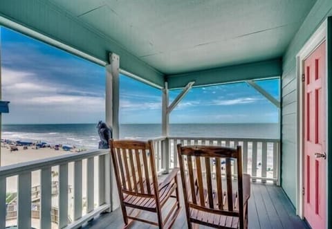 Relax in wooden rockers as you watch waves meet sandy shores from your private oceanfront balcony.