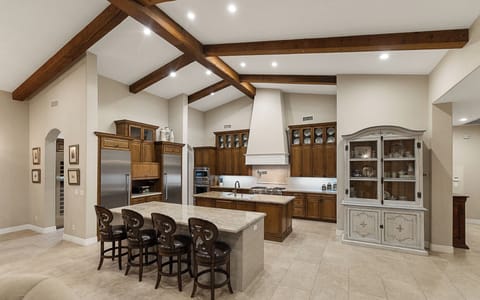 Open kitchen with double islands, granite counters, appliances, and dining area
