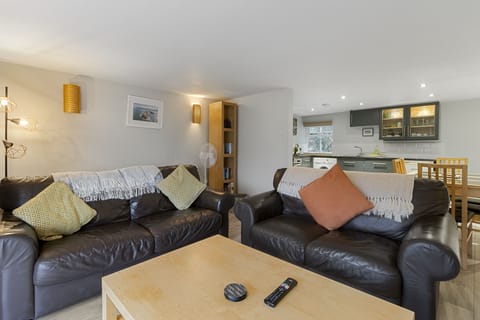 Fully furnished lounge with 2 sofas, TV and views looking out to the harbour.