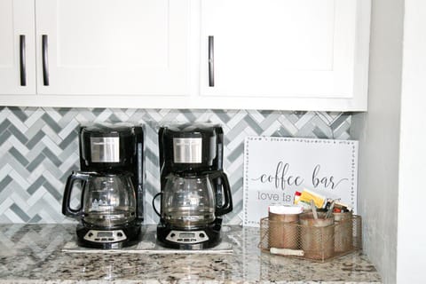 Two coffee pots with coffee, filters, creamers and sweeteners provided