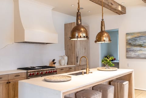 Kitchen Island, Stools, Refrigerator, and Ceiling Lamps.