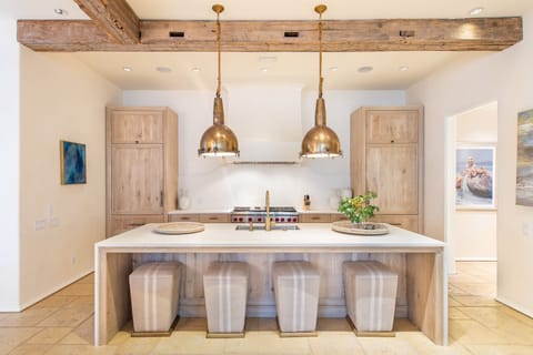 Kitchen with Island, Stools, Dual Refrigerators, and Ceiling Lamps.