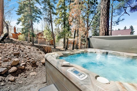 Private outdoor area with a hot tub, BBQ and comfortable seating, surrounded by tall pines, perfect for relaxing under the trees after a day of adventure—enjoy peaceful forest views, fresh air, and a truly rejuvenating stay.