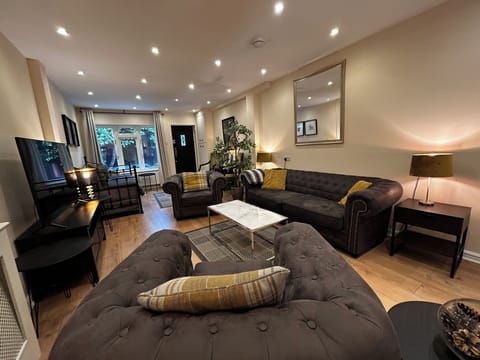 Living room with lots of seating, TV and door leading to private rear garden