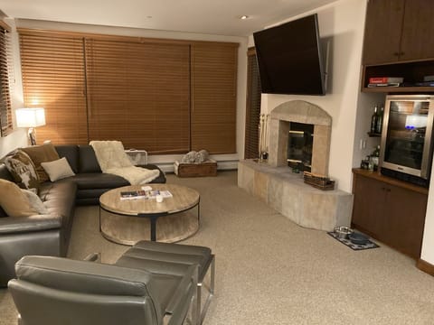 Living room with large HDTV and wood burning fireplace with plenty seating