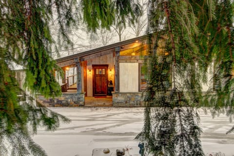- Charming cabin exterior framed by snowy evergreens   - Warm glowing lights and timber design welcome you home   - Ideal mountain retreat for winter getaways and cozy evenings