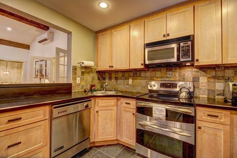 - Sleek kitchen featuring double oven and tile backsplash design   - Granite counters and full amenities for gourmet meal prep   - Warm lighting enhances the rustic yet modern mountain vibe