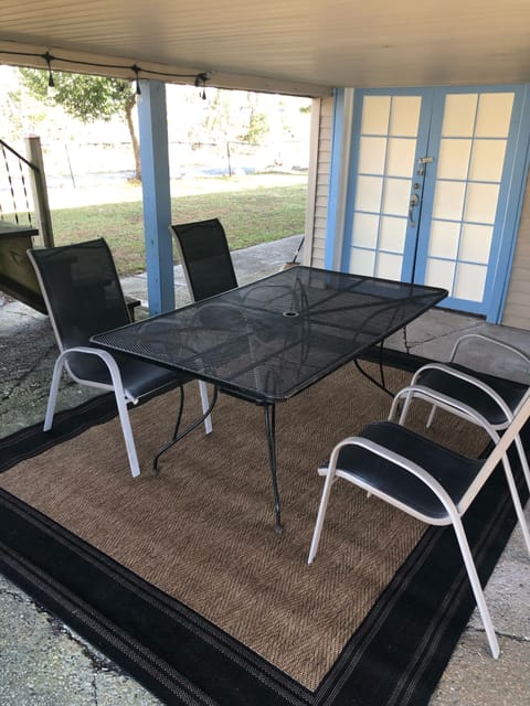 Covered patio in backyard with outdoor dining set