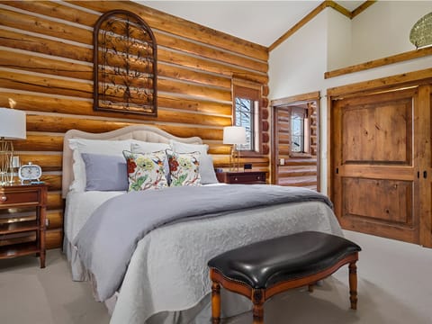 Sink into plush bedding beneath rustic log walls and soft light.