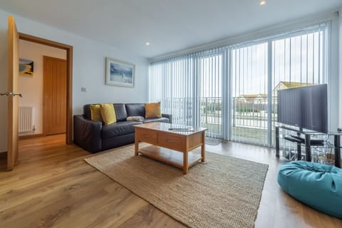 Headland Beaches, Newquay. Upper ground floor: Open plan sitting room with television and doors onto terrace.