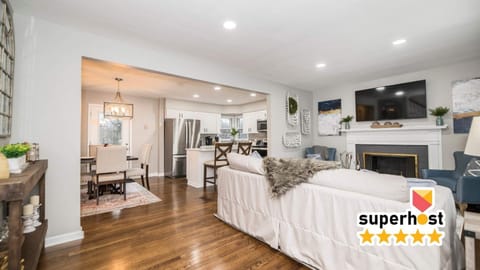 Inviting family room with a 65" TV, cozy fireplace, and bright white walls and fixtures. A stylish and comfortable space perfect for relaxing, watching movies, or spending time together.