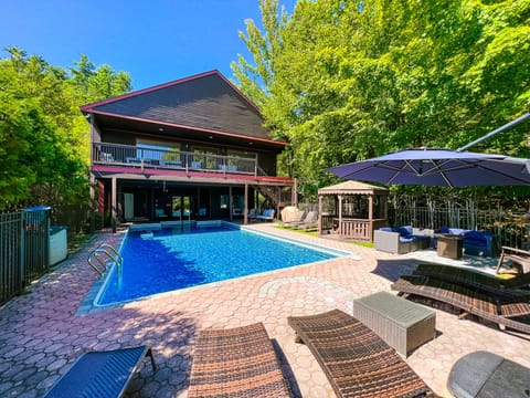 Second-floor porch overlooks the pool, and a staircase leads to the pool area.
