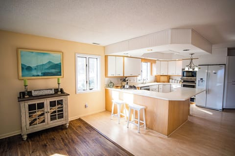 Kitchen on the 2nd Floor, with two ovens, a gas stove, and a bar with stools.