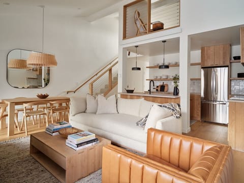 Living Area - Please Note the exposed area above the kitchen does connect to the primary bedroom. A privacy shade has been installed, but does not prevent noise transfer.