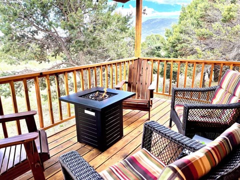 Relax on the covered deck with mountain views and a cozy propane fire table