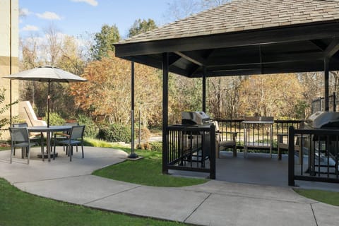 Gather around the grill in the shaded gazebo, a great spot for outdoor meals surrounded by nature.