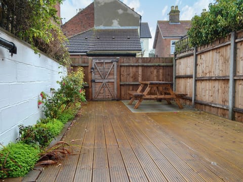 Enclosed courtyard garden with decking and garden furniture | Scira, Sheringham