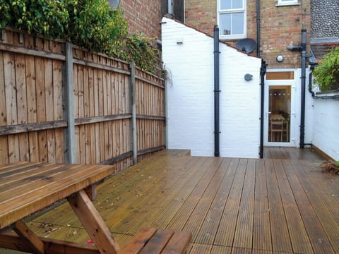 Enclosed courtyard garden with decking and garden furniture | Scira, Sheringham