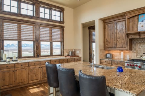 Your gourmet kitchen awaits with stunning mountain views and rustic charm, where granite countertops and professional appliances make cooking a joy while you soak in the serene landscape.