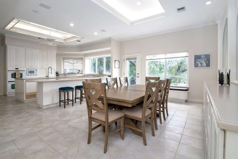 Dining and kitchen share a large open space with windows offering lots of natural light