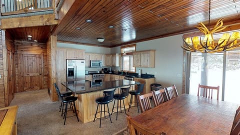 The dining room has a large table with seating and additional seating at the bar of the Island in the kitchen.