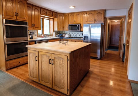 Kitchen with double ovens, cooktop, microwave, dishwasher, refrigerator/freezer.