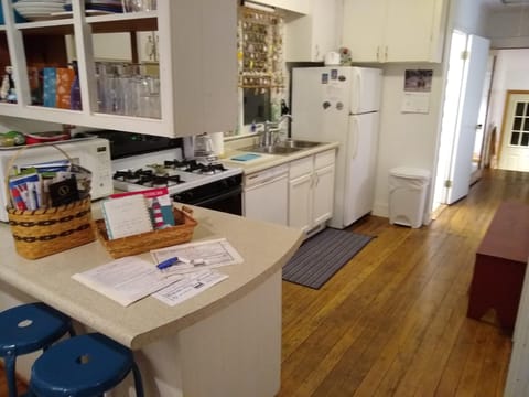 Kitchen equipped with cookware, dinnerware, silverware, and coffee maker.