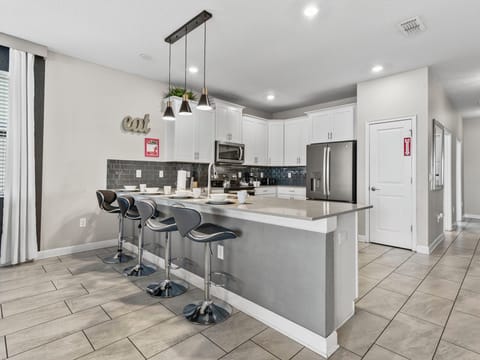 Kitchen fronting the countertop table with four high chairs- either a quick coffee or snack this is the perfect place to sit