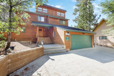 Welcoming cabin entry surrounded by towering pine trees, offering fresh mountain air and a peaceful forest setting—the perfect first impression for your Big Bear Lake getaway.