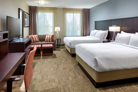 Comfortable bedroom with queen beds and warm lighting.