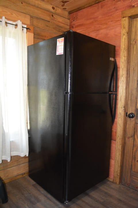 Utility room adjacent to kitchen includes refrigerator/freezer with ice maker.