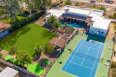 A picturesque masterpiece surrounded by lush greenery, featuring exquisite architecture, glistening pools, and vibrant gardens. The blend of colors and inviting outdoor spaces promises a serene and luxurious