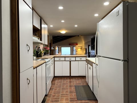 Open kitchen w/ loads of cooking supplies, including a waffle maker & fondue pot