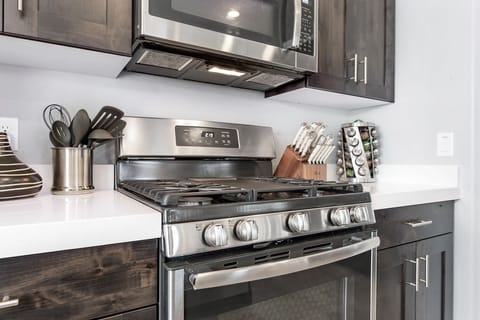 Fully stocked kitchen with a 4-burner gas stove and large middle grill