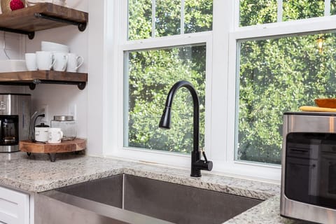 Large farm sink, plenty of dishes, pots, pans, utensils, and small appliances