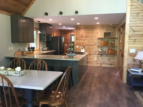 View toward Front Entryway, Stocked Kitchen, and Dining.