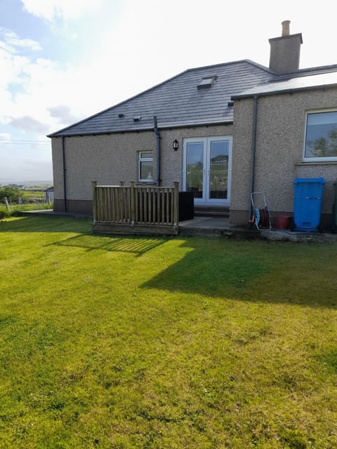 Back of the house with decking and garden furniture plus barbecue. 