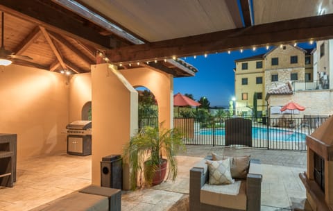 Outdoor courtyard with lounge seating and gas grill.