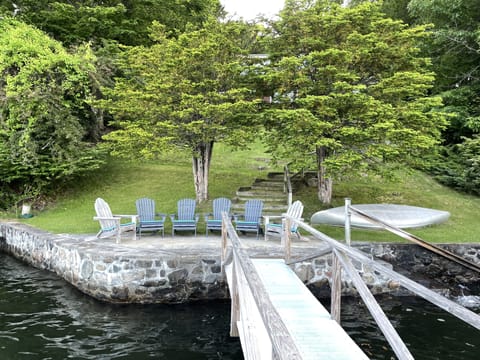 Large stone patio at waters edge with stone steps into the water. 