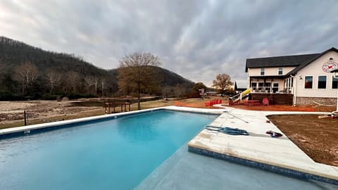 The pool is in and almost complete. It's a sports pool with a shallow end on each side and then deeper in the middle - great for playing volleyball. The tanning ledge is perfect for hanging out or playing with toddlers.