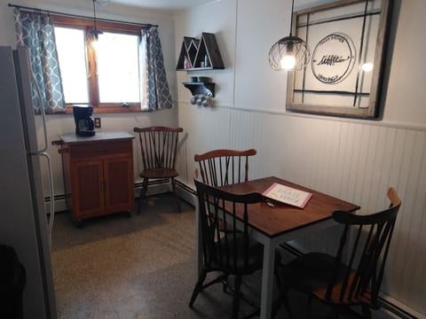 eating area with seating for 4, a coffee bar and large refrigerator.