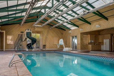 pool showing slide games, spa, and kitchen