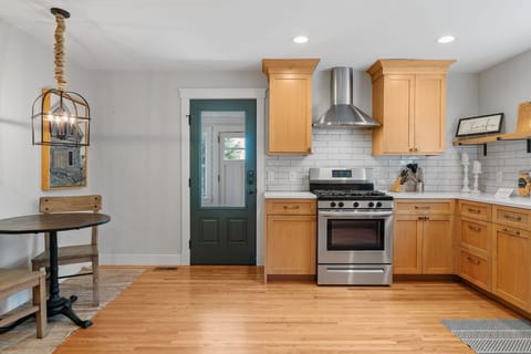 Your fully equipped kitchen features warm wood cabinets, stainless appliances, and subway tile backsplash - perfect for creating memorable meals.