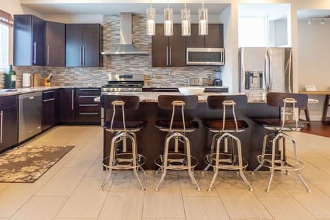 The kitchen island offers seating for four. - Upper Townhouse