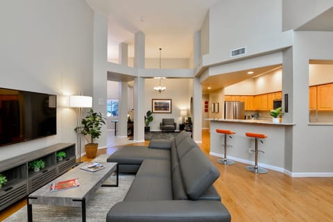 The main LR has 65" wall-mounted HDTV, adjustable back on faux leather couch.