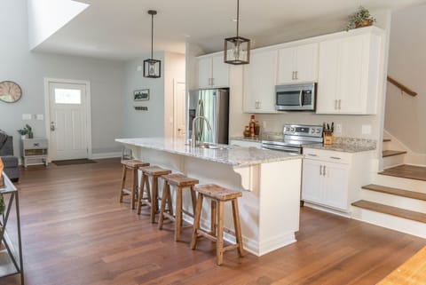 Kitchen. Stairs to bedrooms and another full bathroom. Extra seating at island.